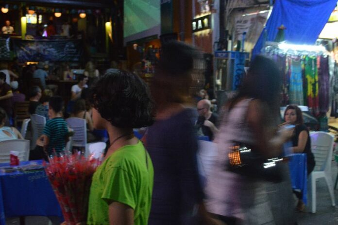 A girl selling roses on Khaosan Road in Bangkok.