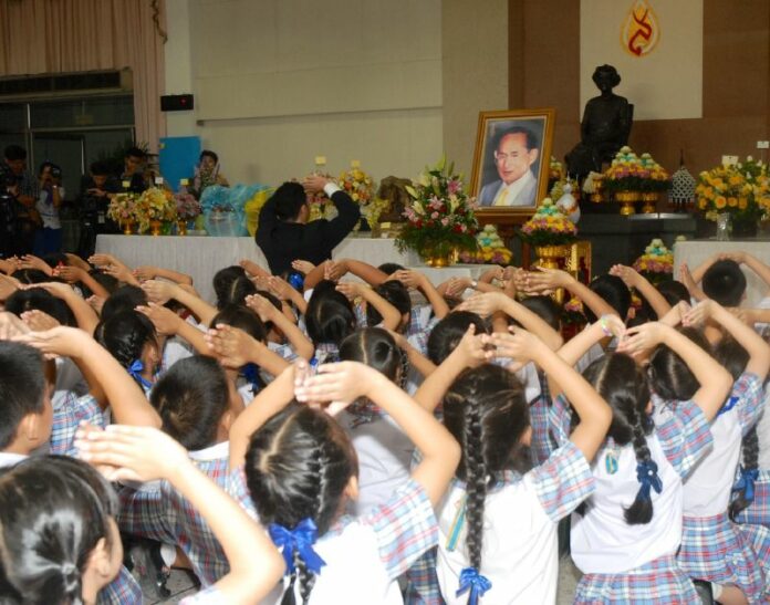 School children paying respect to a portrait of HM the King to wish him a speedy recover from gallbladder surgery on 6 October 2014.<br />