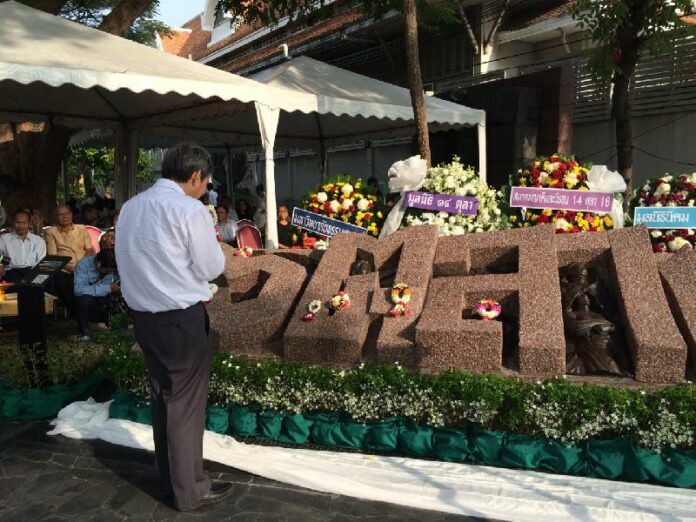 A man praying to the October 6, 1976 monument at Thammasat University on 6 Oct 2014.