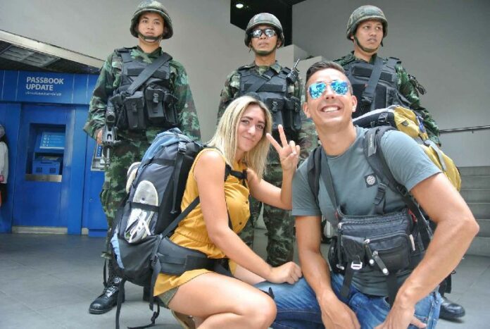 Tourists pose with soldiers on 20 May 2014, hours after the Thai army declared martial law.<br />