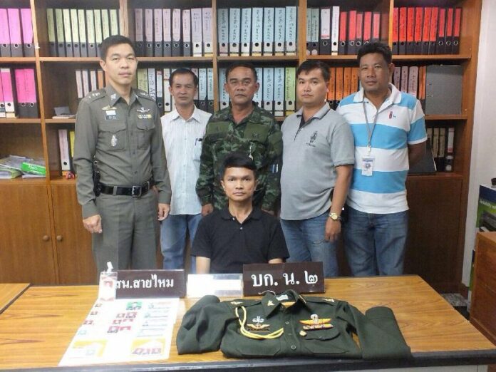 Somkiat Ekkawipat (sitting), 37, was arrested for posing as an army captain to get out of a paying a traffic violation, 21 Oct 2014.