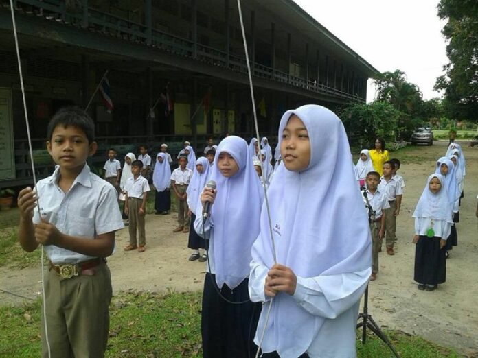 Muslim students raising a Thai flag for the national anthem at a school in Narathiwat, 3 Nov 2014.<br />
