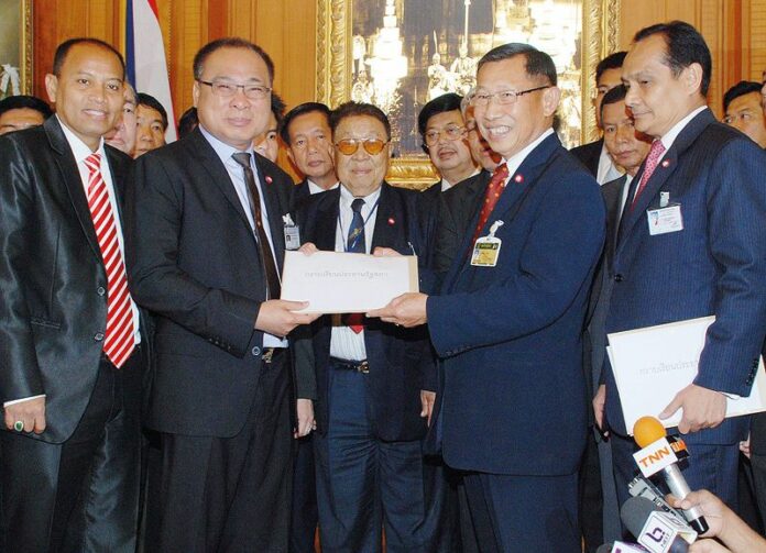House Speaker Somsak Kiatsuranond (L) receiving draft of constitution amendment from Pheu Thai MPs at the Parliament on 20 March 2013. Somsak would later face impeachment procedure from the national anti-graft agency for his role in the amendment. <br />