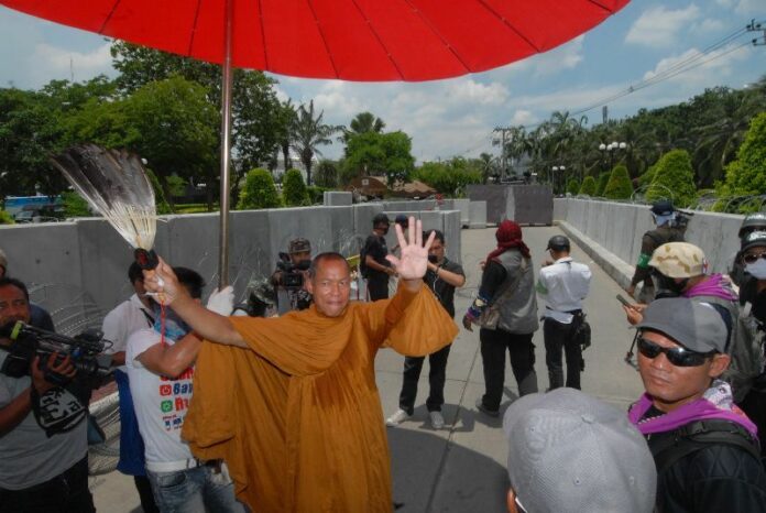 Buddha Issara leads anti-government protesters to storm a police government in Bangkok on 9 May 2014.