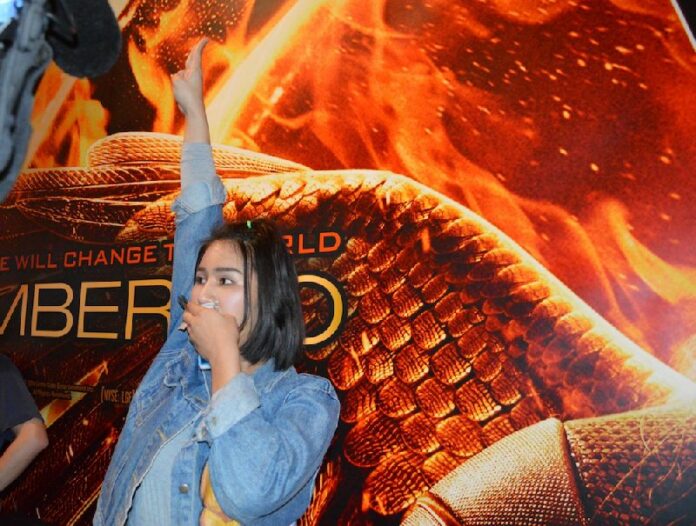 Natcha Kong-udom, a first year student at Bangkok University, was arrested by police after she began flashing the three-finger salute in Siam Paragon's cinema, 20 Nov 2014.