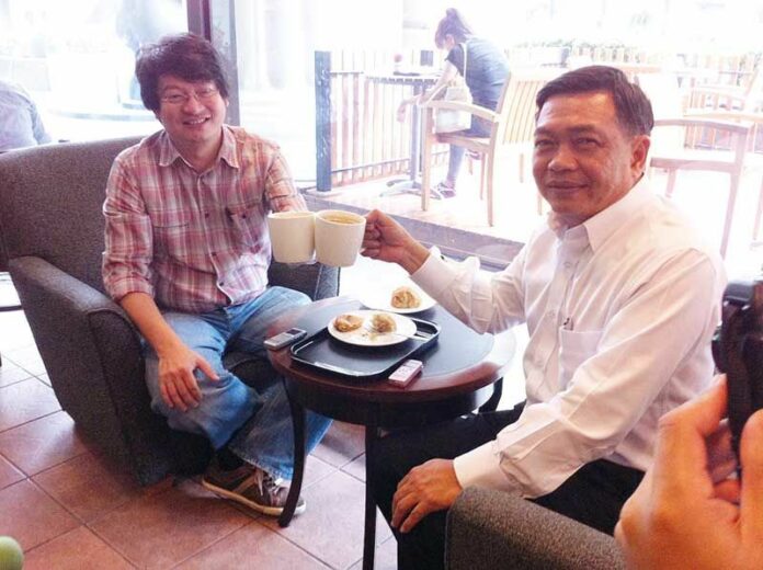 Alongkorn Ponlaboot poses for photographs during his meeting with Sombat Boon-ngarmanong, a Redshirt leader, on 8 June 2013 (photo by Matichon)