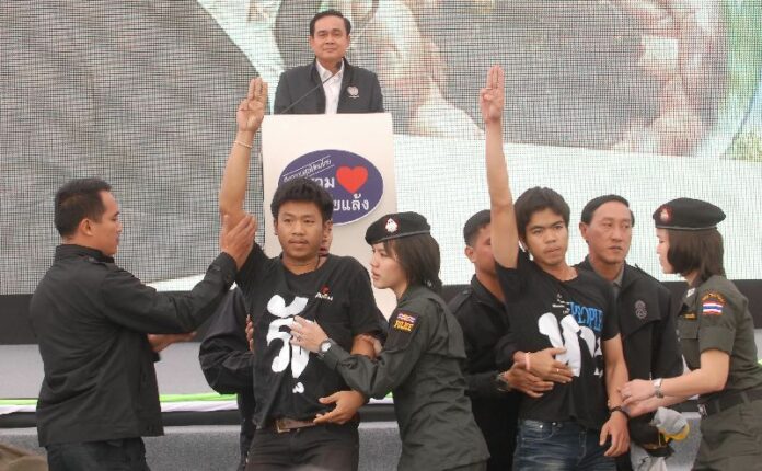 Student activists in Khon Kaen interrupt PM Prayuth Chan-ocha on 19 November to flash an anti-coup salute.<br />