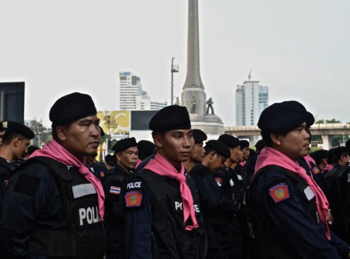 Riot police stationed at an anti-coup protest by Bangkok's Victory Monument in May 2014.<br />