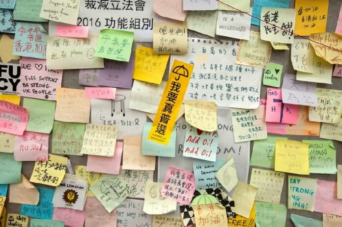Post-it notes are seen on the 'Lennon Wall' at the Admiralty camp, occupied by pro-democracy supporters in Hong Kong on December 10. EPA/ALEX HOFFORD<br />