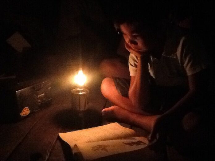 A child reads by candle light in Nong Pai Yai village.