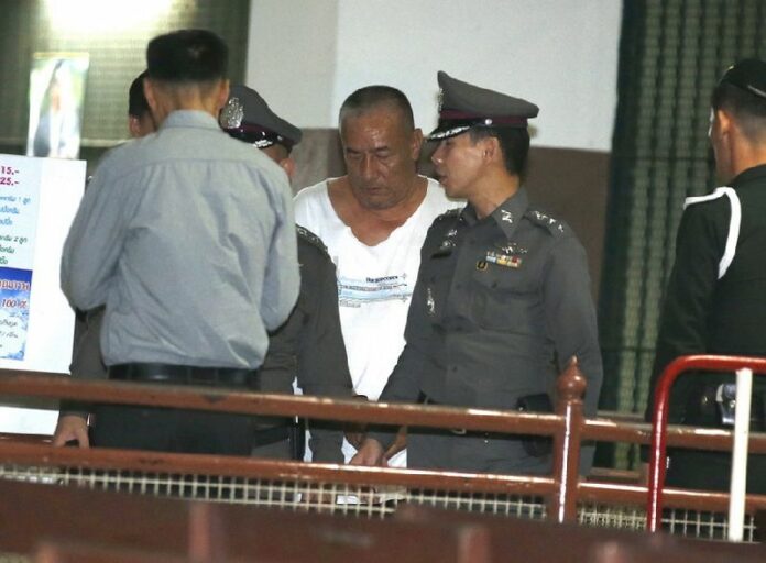 Thai alleged lese majeste former senior police officer Pongpat Chayapan (C) is escorted by police officers as he leaves the criminal court in Bangkok, Thailand, 24 November 2014. Over 260 Thai police officers serving in the same unit as the former commander will be reassigned. EPA/NARONG SANGNAK<br />