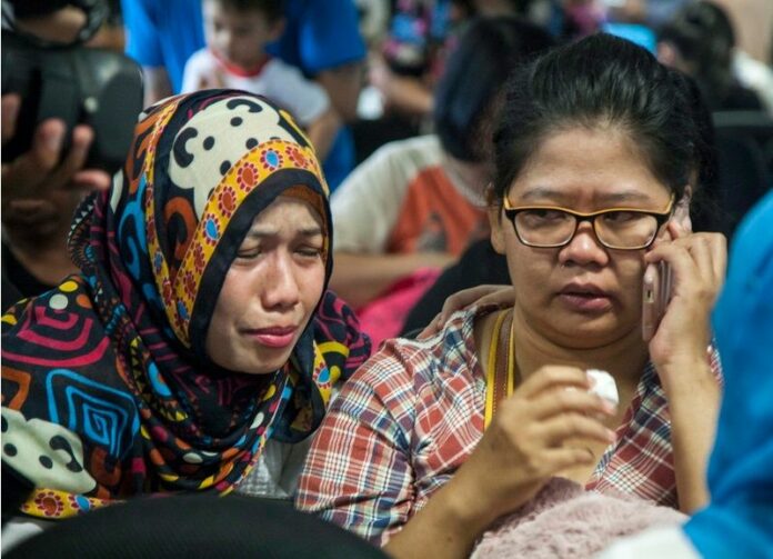 Relatives wait for news of the missing AirAsia plane at Juanda Airport, in Surabaya, Indonesia. EPA/FULLY HANDOKO