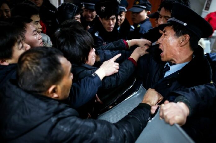 Security guards hold a line to keep relatives away from the emergency area of a hospital where some people injured in the stampede were admitted, in Shanghai, China, 01 January 2015. A stampede on New Year's Eve left 35 dead and more than 40 injured in Shanghai, marring celebrations that drew revellers around the world. The accident occurred 25 minutes before midnight at the crowded Chen-Yi Square along the city's famed Huangpu River waterfront. EPA/XING ZHE CHINA OUT<br />