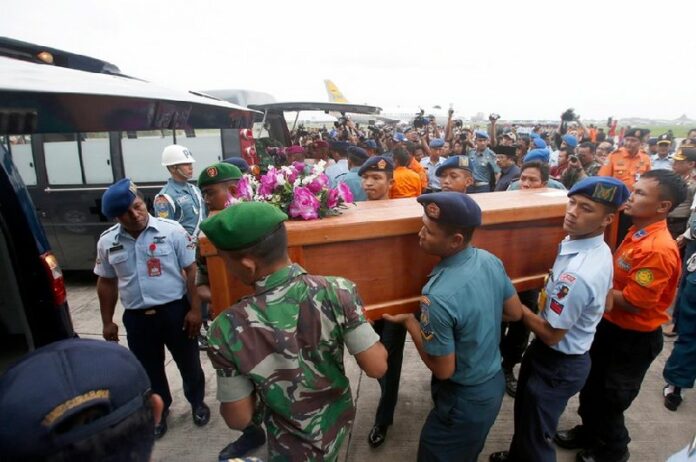 Indonesian military personnel in Surabaya carry one of two coffins with remains recovered from the AirAsia crash site as they arrive at Juanda Airport, in Surabaya. Photo EPA/MADE NAGI<br />