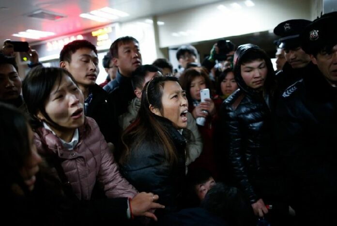 Security guards hold a line to keep relatives away from the emergency area of a hospital where some people injured in the stampede were admitted, in Shanghai, China, 01 January 2015. A stampede on New Year's Eve left 35 dead and more than 40 injured in Shanghai, marring celebrations that drew revellers around the world. The accident occurred 25 minutes before midnight at the crowded Chen-Yi Square along the city's famed Huangpu River waterfront. EPA/XING ZHE CHINA OUT<br />