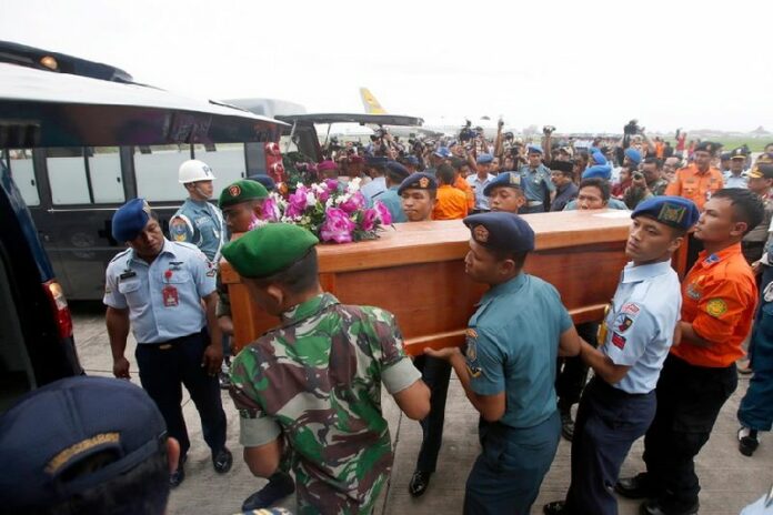Indonesian military personnel in Surabaya carry one of two coffins with remains recovered from the AirAsia crash site as they arrive at Juanda Airport, in Surabaya. Photo EPA/MADE NAGI<br />