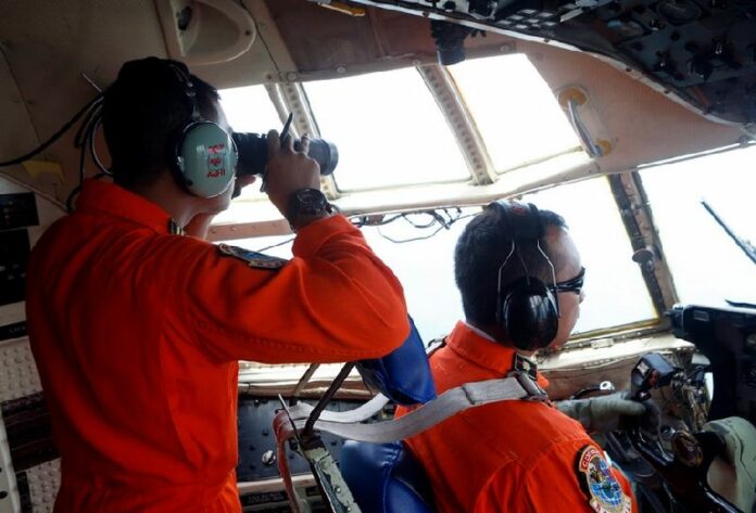 Indonesian Air Force members look the cockpit windows of C-130 Hercules plane during a search and rescue operation as they search for the missing AirAsia plane over Bangka Island, Indonesia. The search for a missing AirAsia plane that left Indonesia with 162 people on board expanded, with more aircraft and ships sent to scour a wider area. EPA/ADI WEDA <br />