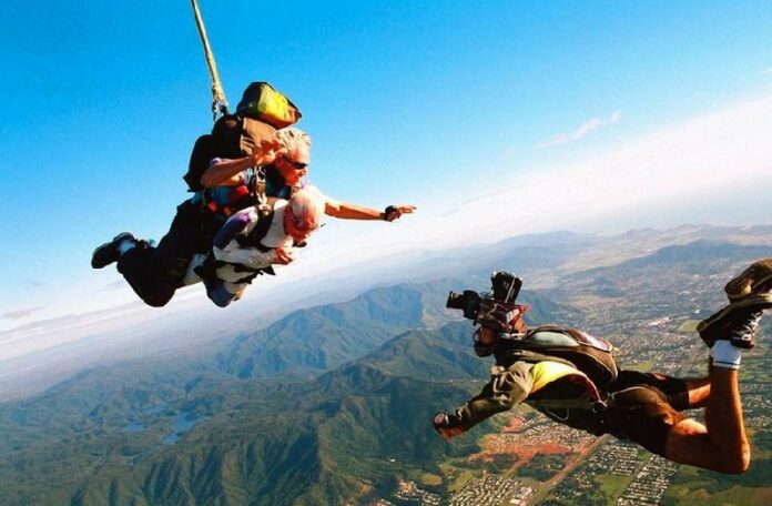 A file photo shows Frank Moody, 101, (C) during his tandem skydive with Karl Eitech (L) over Cairns in Australia, as a cameraman films (R) the event for the record books on 16 June 2004. Thirteen people had the parachute jump of their lives, leaping for safety before their skydiving plane crashed into New Zealand's largest lake, Lake Taupo. Photo: Skydive Cairns/ Ho dpa<br />