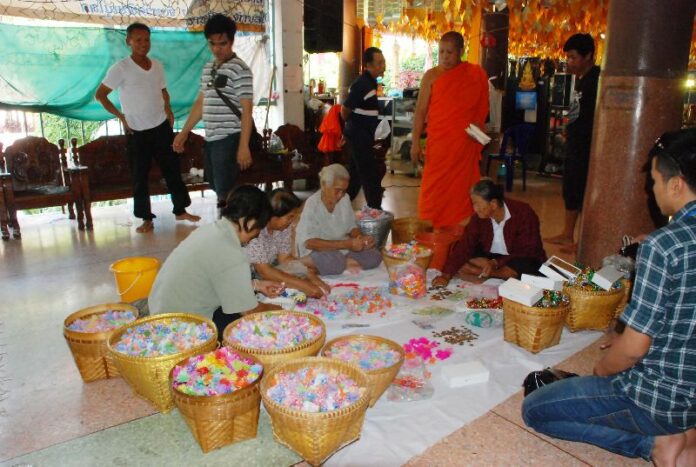 Monks and temple-goers prepare the gifts for Friday's giveaway. Wat Ratchaburana temple in Pitsanulok province, 8 Jan 2015.