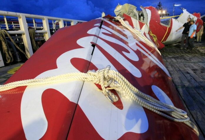 Investigators next to the tail of the crashed AirAsia aircraft during the recovery mission at Panglima Utar Kumai Harbour in Kumai, Central Borneo, Indonesia, January 11. EPA/BAGUS INDAHONO<br />
