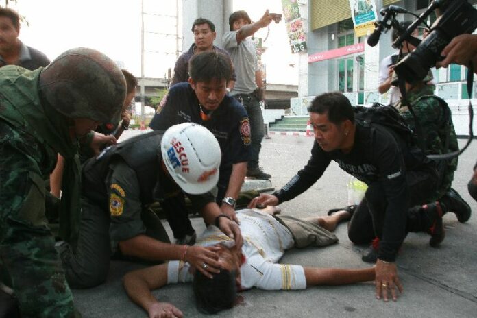 Rescue workers rush to the aid of Arkaew Saelew, who was allegedly shot by the popcorn gunman and later died in a hospital. 1 Feb 2014.<br />