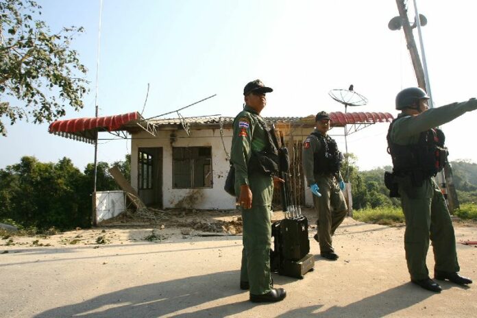 Police officers inspecting the scene where a bomb exploded near a heckpoint in Yala's Mueang district on 28 Jan 2015.