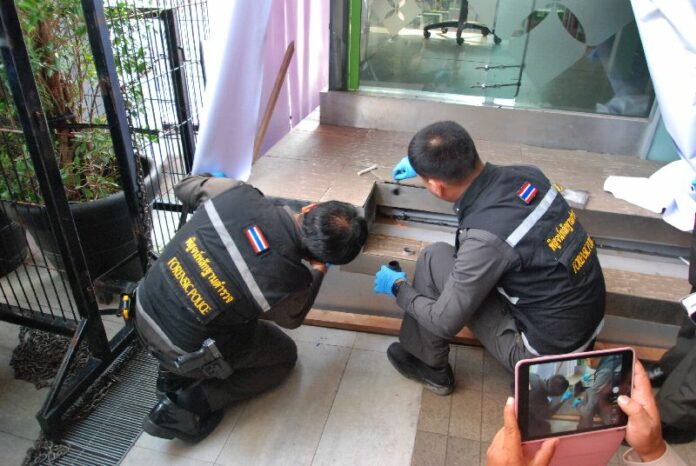 Forensic police investigate the scene where 2 IEDs went off in front of Siam Paragon in Bangkok, 2 Feb 2015.