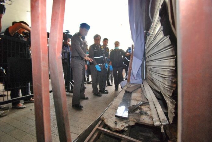 Police inspect the site of two bomb blasts near a luxury shopping mall entrance in Bangkok, Thailand, 02 February 2015.<br />