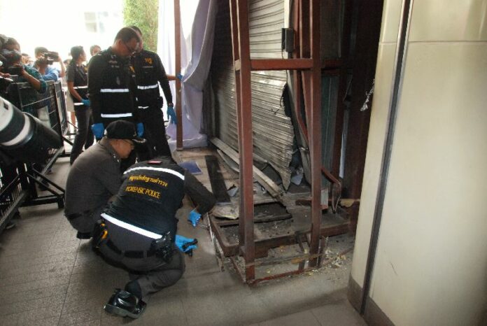 Police inspect the site of two bomb blasts near a luxury shopping mall entrance in Bangkok, Thailand, 02 February 2015.<br />