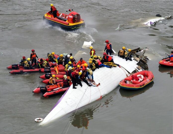 Search and rescue team members operate on a TransAsia Airways passenger plane which crashed into the Keelung River in Taipei, Taiwan, 04 February 2015. Of the 58 people on board the ATR 72 plane, at least 8 were killed, 16 injured and the rest rapped inside the plane. EPA/DAVID CHANG<br />