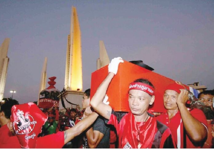 Redshirt demonstrators carry coffins of protesters killed in the crackdown by the military in Bangkok, 11 April 2010.<br />