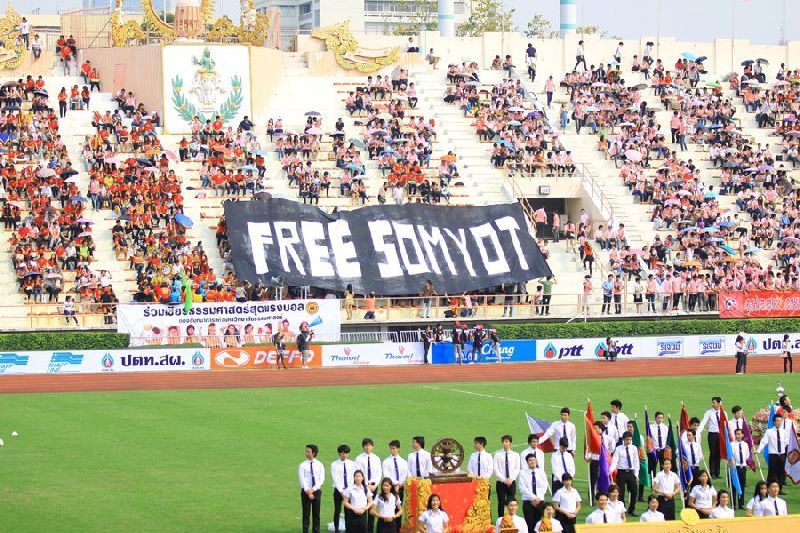 Activists unfurl a banner calling for the release of Somyot Prueksakasemsuk, a magazine editor jailed for allegedly insulting the Thai monarchy, during the Chulalongkorn - Thammasat annual football match on 2 Feb 2013. <br />