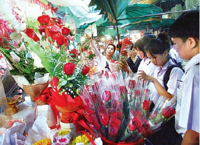 Teens buy roses for Valentine's Day in Bangkok on 13 Feb 2013.