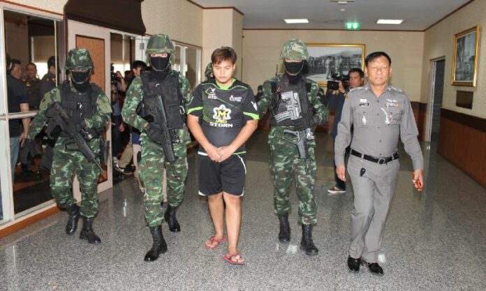 Soldiers escort Krit Bootdeecheen, 25, to the Royal Thai Police headquarters on 9 Feb 2015.