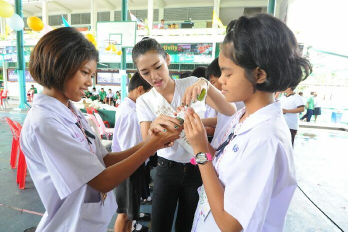 Representatives from Plan International's branch in Thailand teach students at a school in Bangkok about condom uses, 13 July 2013