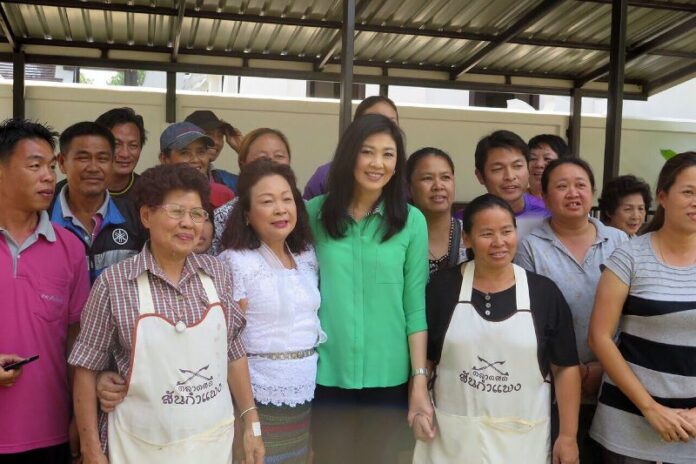 Former PM Yingluck Shinawatra poses for a photo with vendors at a market in Chiang Mai, 10 Feb 2015.