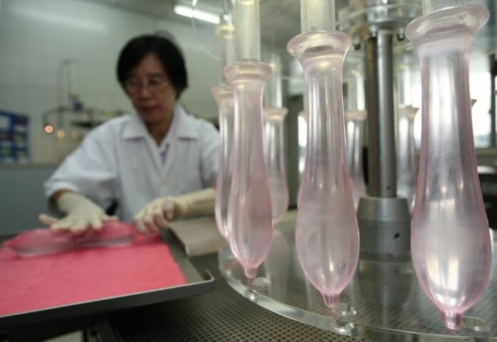 A laboratory technician at Thailand's Department of Medical Sciences tests newly made condoms at the Ministry of Public Health in Bangkok, Thailand, 27 September 2010. Thai education officials have reversed course and will allow condom vending machines to be placed in secondary schools, a report said Tuesday. EPA/NARONG SANGNAK<br />