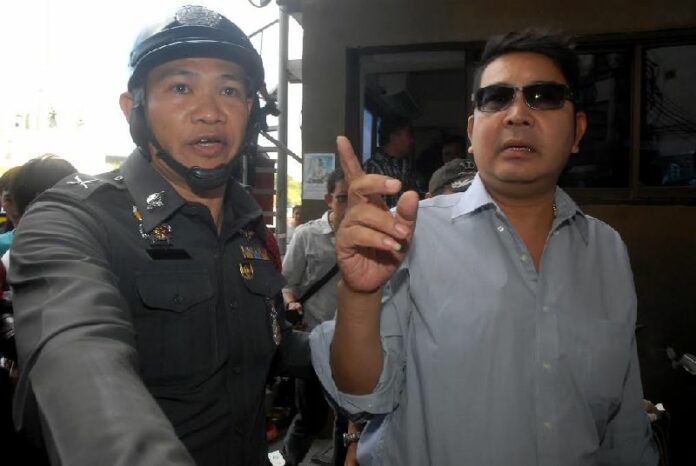 Activist Akkrit Noonchan was detained by security officers for handing out free t-shirts at Victory Monument in Bangkok on 22 Feb 2015