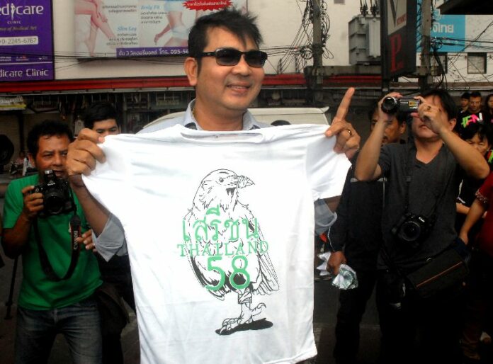 Activist Akkrit Noonchan was detained by security officers for handing out free t-shirts at Victory Monument in Bangkok on 22 Feb 2015.<br />