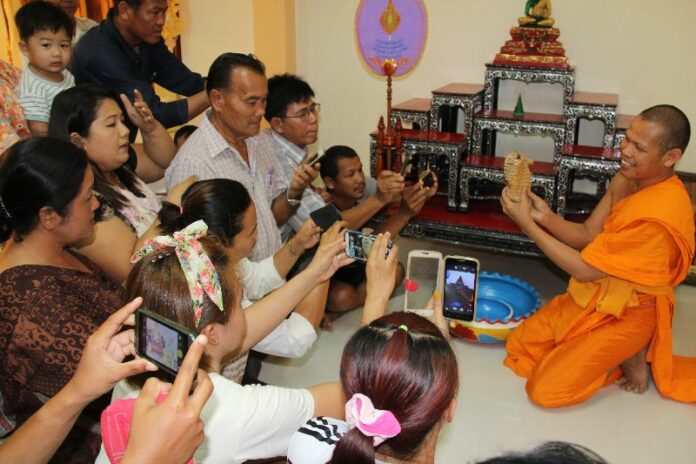 A monk showing an alleged "Naga fossil" to temple-goers in Uttradit province, 23 Feb 2015.