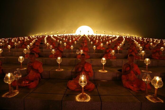 Novices light candles as they join thousands of monks in chanting to celebrate Makha Bucha day at Wat Dhammakaya on Feb. 25, 2013. Photo: Rungroj Yongrit / EPA