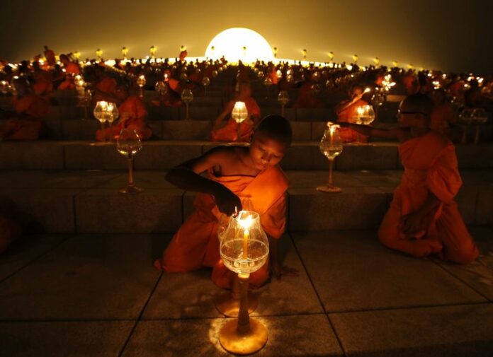 Novices light candles as they join thousands of Thai Buddhist monks in chanting to celebrate Makha Bucha day at Dhammakaya Temple in Pathum Thani province, on the outskirts of Bangkok in February 2013. Photo: Rungroj Yongrit / EPA