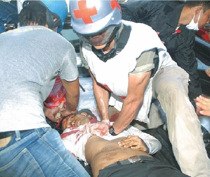 Medics give aid to a member of the Redshirt "guard unit" who was mortally wounded by the soldiers' gunfire in Lumpini Park, 13 May 2010