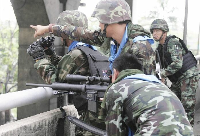 A military sniper aims at Redshirt protesters during a clash on Viphavadee Road in Bangkok, 28 April 2010.