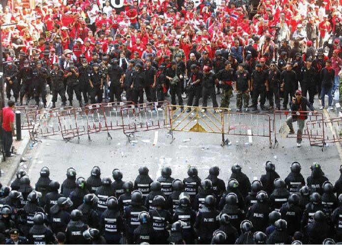 Redshirt demonstrators face off with riot police near Ratchaprasong Intersection in Bangkok, 6 April 2010.<br />