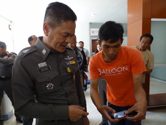 Supot Angkham, 29, showing his phone to police at Hua Hin station, 28 Feb 2015.
