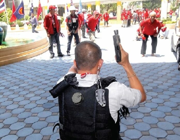 A police officer drew a handgun in an effort to stop the Redshirts from entering the hotel in Pattaya on 11 April 2009.