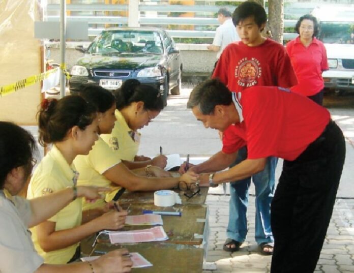 Anti-coup activist Weng Tojirakarn votes in the 2007 referendum, wearing red to signify his opposition to the constitution draft, 19 August 2007.<br />