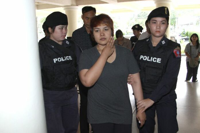 Nattathida Meewangpla flashing an anti-coup hand gesture while police escort her to their HQ in Bangkok on 17 March 2015.<br />