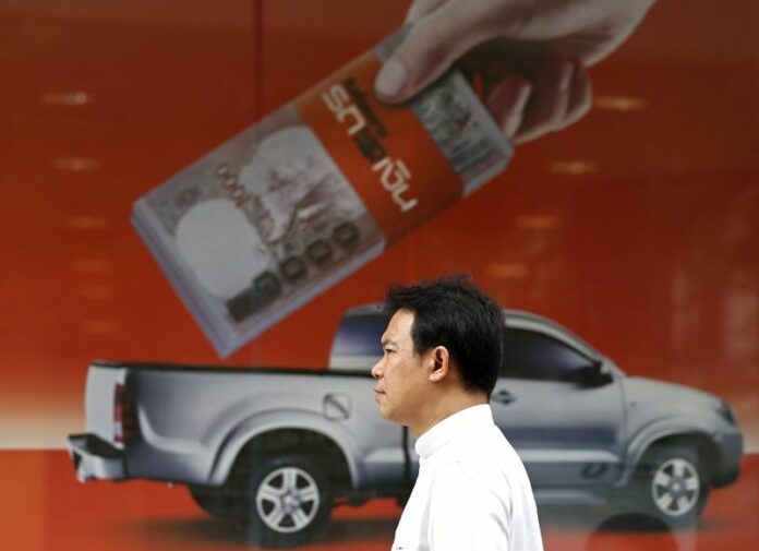 A Thai office worker walks past an ad for bank loans in Bangkok, Thailand, 08 July 2013. Developing Asia will show strong economic growth this year and in 2016, but an impending rise in US interest rates may require monetary responses to maintain stability, an Asian Development Bank report said Tuesday. EPA/RUNGROJ YONGRIT<br />